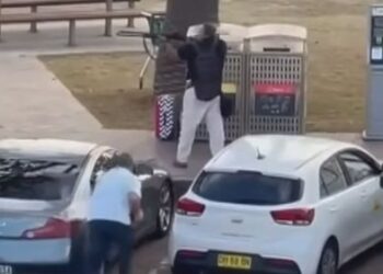 Герой подкрадывается к вооруженному преступнику на пляже Бонди и отбирает у него оружие.