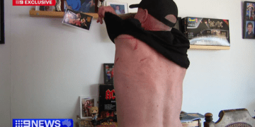 Голый мужчина противостоит злоумышленникам в масках, которые выбили дверь. Мужчина противостоит злоумышленникам, которые выбили дверь.